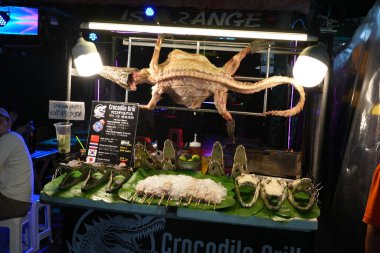 Bangkok, Tayland - 26 Kasım 2024: Khaosan Yolu 'nda timsah eti ya da kızarmış barbekü timsahı, egzotik yemek ve Taylandlı gezginler için ızgara yeni tuhaf lezzet mutfağı.