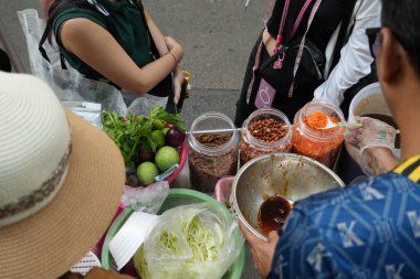 street food stall preparing SomTum or papaya salad with ingredients pepper, tomato, lemon and garlic is traditional Thai food. clipart