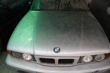 Bangkok, Thailand - November 27, 2024: abandoned BMW 5 sedan car. silver metallic color BMW 5 Series 525i E34, luxury old 90s car. parked dusty and old car clipart