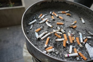 cigarette butt on silver ashtray, Old cigarettes filter in ashtray at smoking area