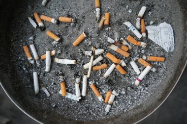 - Sigara. Sigara izmaritleri ve kibritler sigara içme alanındaki kül tablasında yatıyor.