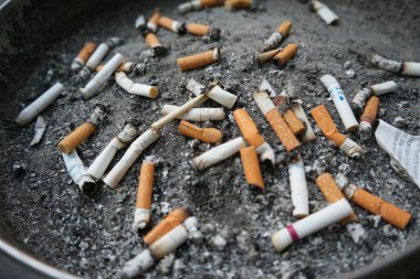 Sigara izmaritleriyle dolu kül tablası, sigara içme alanındaki endüstriyel kül tablasını kapat.