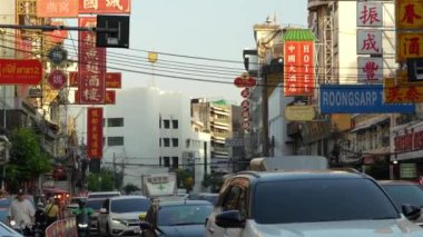 Bangkok, Tayland. 21 Kasım 2024 - Çin Mahallesi Caddesi, öğleden sonra. Geceleri Çin Mahallesi sokakları. Turistler ve bir grup insan sisli Bangkok 'ta triportörler ve arabalar arasında ve renkli mağazaların önünde..