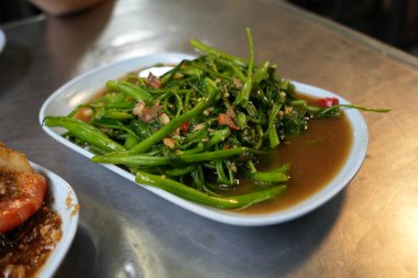 Beyaz tabakta srimp macunlu su ıspanağı. Su ıspanağı Asya 'da popüler bir yemektir. Karıştırılmış