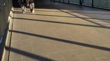 Gün ortası sokakta yürüyen insanların görüntüsü.