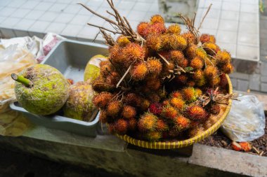 Taze turuncu ve kırmızı rambutan, kırmızı kabuklu, beyaz etli ve kahverengi tohumlu bir meyvedir. Asya 'daki geleneksel pazarda satılan tatlı bir tadı var. ya da Nephelyum Lappaceum