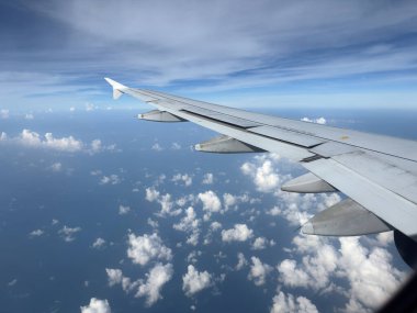 Kanat manzarası uçak penceresinden harika bulutlar ve mavi gökyüzü manzarası