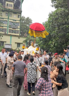 People holding the golden statue of Guru Padmasambhava takes part in the sacred rally as other tries to enter under the statue to get blessings on the occasion of Guru Rimpoche's Thunkar Tshechu at Gangtok in Sikkim.  clipart