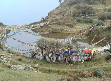 Renkli bayraklar dalgalanıyor ve Nepal 'deki Kaal Pokhari' ye yansıtılıyor. Bu zehirli bir göl ve 80 'lerde otlanırken gölden su içen birçok inek öldü. Ondan sonra hayvan otlaması yasaklandı..  