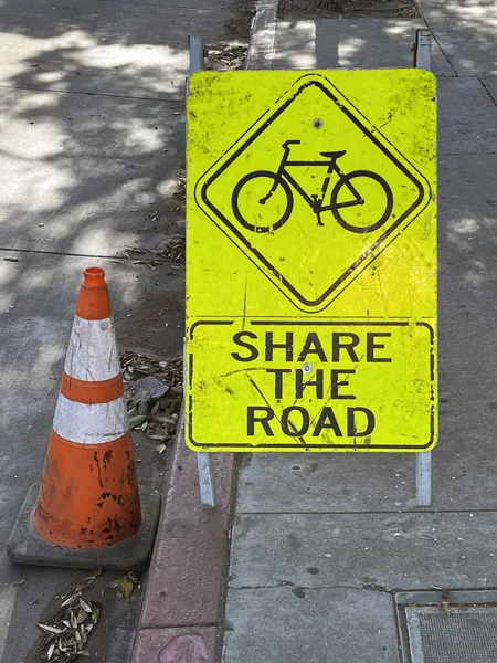 BICYCLES SHARE THE ROAD sign at an urban street construction site