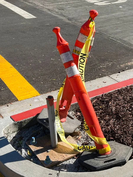 Traffic pylons and safety tape at a city street construction site