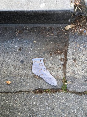 Sokakta kaybolmuş tek bir beyaz çorap.