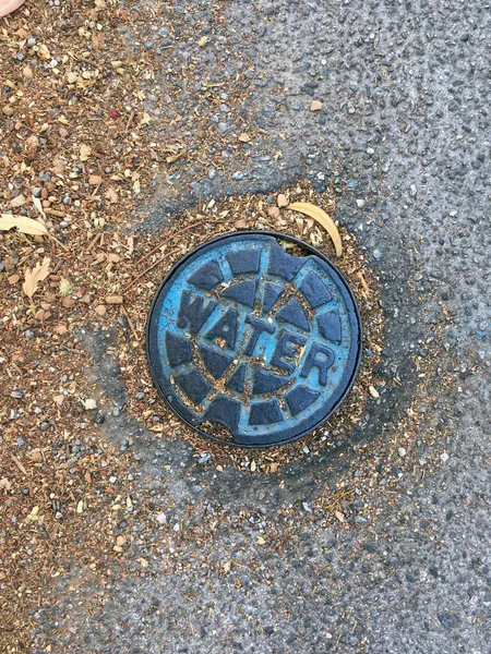 市内歩道の下の水バルブ用金属バルブカバー — ストック写真