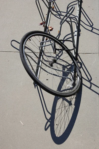 자전거의 나머지 도난당한 앞바퀴는 자전거 선반에 고정되어 있었다 — 스톡 사진