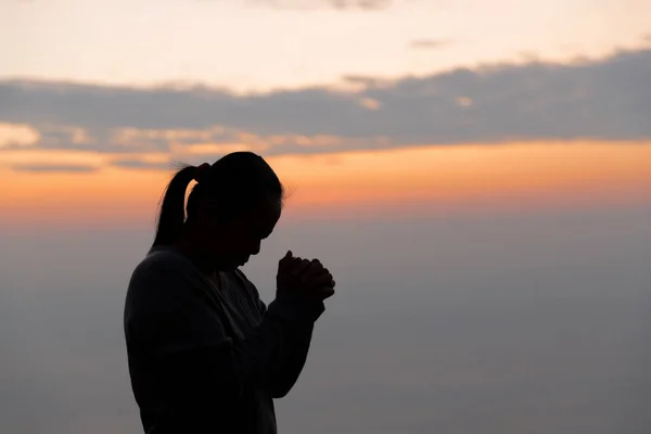 Silhouette of woman hand praying spirituality and religion, female worship to god. Christianity religion concept. Religious people are humble to God. Christians have hope faith and faith in god.