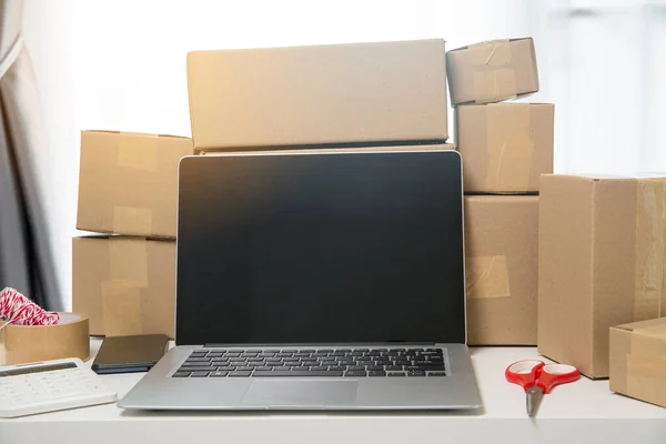 Equipments for SME online business, delivery business laptop, barcode, boxes, checking product on stocks or cardboard parcels. Small business working at home office. delivery service product at home.