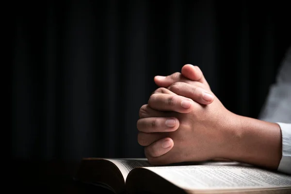 信仰神圣的圣经概念 一位女性祷告者的手在教堂里用黑色背景的神圣圣经崇拜上帝 相信耶稣的基督教妇女阅读和研究圣经的恩典 — 图库照片