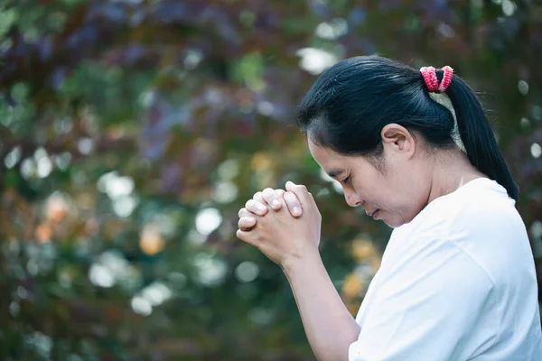 Prayer person hand in black background. Christian catholic woman are praying to god in dark at church. Girl believe and faith in jesus christ. Christ religion and christianity worship or pray concept.