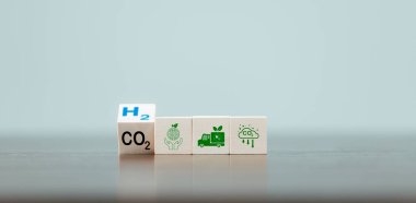 Bedava karbon, alternatif enerji ve küresel iklim değişikliği kavramları. Tahta küp blokları CO2 karbondioksitle çevirip masa arkasında H2 Hidrojen metnine çevirmek. Sürdürülebilir araba enerjisi.