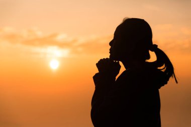 Hristiyan 'ın ibadetini kavrayın ya da Tanrı' ya dua edin. Hristiyan kadın silueti sevgi, inanç, Tanrı 'ya bağlılık ve gündoğumunda gökyüzü arka planında. Barış, zafer ve umut için Tanrı 'ya ibadet edin. din