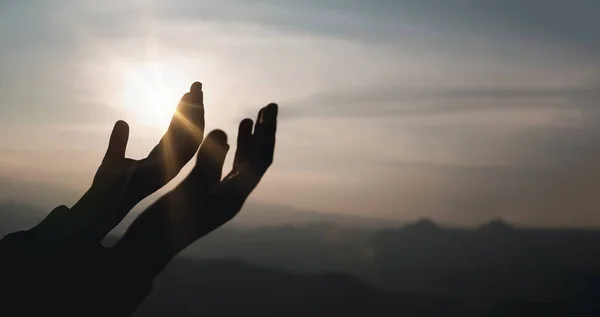 Banner of Faith christianity with christian worship concept. Spiritual prayer hands over sun shine with blurred beautiful sunset background. Woman praying to god with hopeful blessing against sunset.