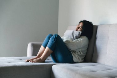Concept of sad teenage girl depression. Upset teenage girl sitting at window indoors. Anxiety young woman Despair and stress. Lonely and unhappy female are social victims. loneliness youth in home.