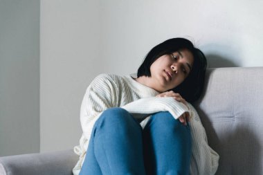 Concept of sad teenage girl depression. Upset teenage girl sitting at window indoors. Anxiety young woman Despair and stress. Lonely and unhappy female are social victims. loneliness youth in home.