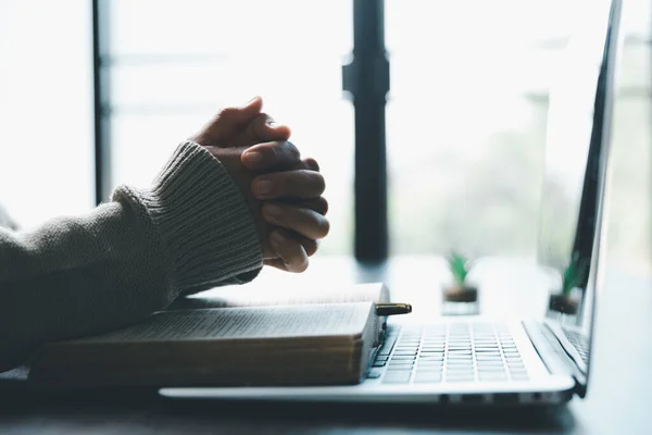 Christian online technology concept. Hands praying of christian with digital computer laptop, Online live church for sunday service. Asian catholic woman are reading Holy bible book and online study.