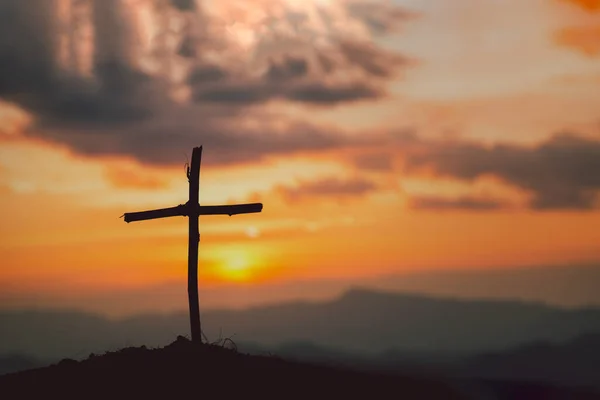 Crucifixion Of Jesus Christ - Cross At Sunset. The concept of the resurrection of Jesus in Christianity. Crucifixion on Calvary or Golgotha hills in holy bible.