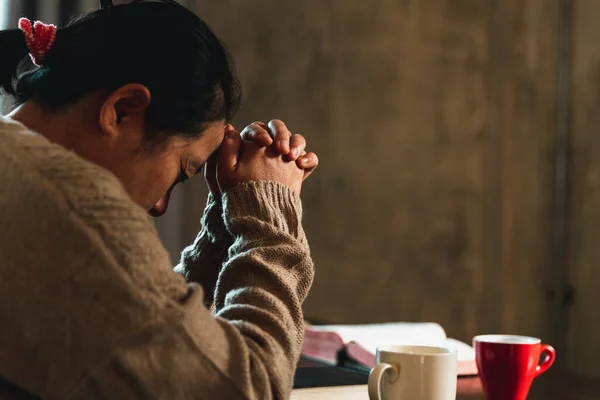 Christian life crisis prayer to god. Woman pray for god blessing to wishing have a better life. Woman hands praying to god with the bible. Begging for forgiveness and believe in goodness.