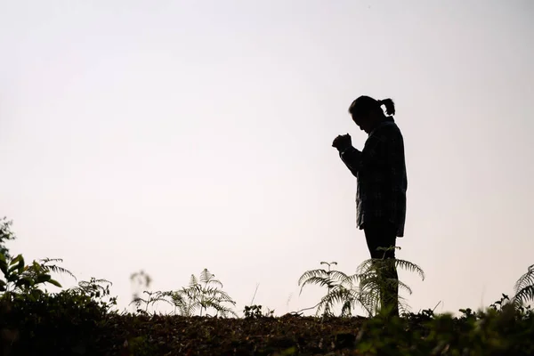 Silhouette of woman kneeling down praying for worship God at white background. Christians pray to jesus christ for calmness. In morning people got to a quiet place and prayed. copy space.
