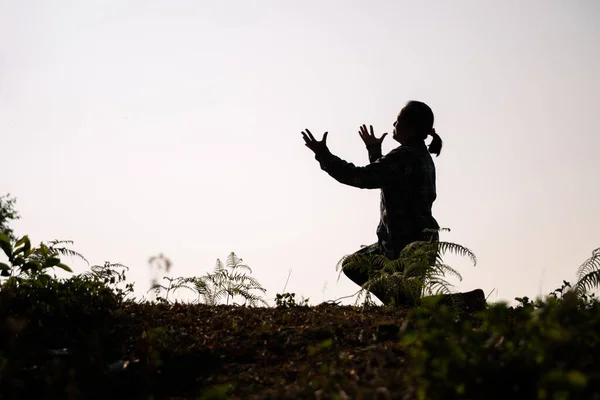 Silhouette of woman kneeling down praying for worship God at white background. Christians pray to jesus christ for calmness. In morning people got to a quiet place and prayed. copy space.