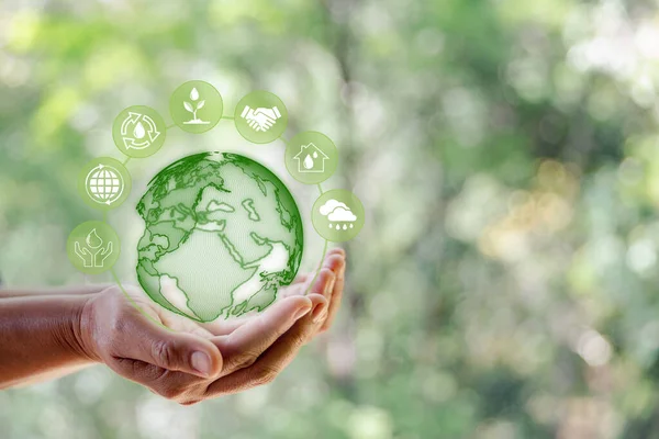 Dünya Çevre Günü. Yeşil doğa arka planında insan elinin simgesi olan dünya teknolojisi. Çevreyi kurtarmak, temiz gezegeni kurtarmak, ekoloji kavramı. Ekoloji ve Sürdürülebilir Geliştirme.