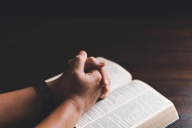Kadın elleri İncil 'le Tanrı' ya dua ediyor. Kadınlar daha iyi bir hayat dilemek için Tanrı 'ya dua ederler. Af diliyor ve iyiliğe inanıyor. Kilisenin inanç kavramında kutsal İncil.
