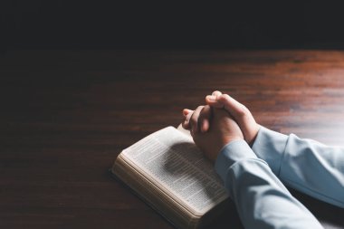 Kadın elleri İncil 'le Tanrı' ya dua ediyor. Kadınlar daha iyi bir hayat dilemek için Tanrı 'ya dua ederler. Af diliyor ve iyiliğe inanıyor. Kilisenin inanç kavramında kutsal İncil.