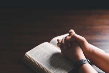 Kadın elleri İncil 'le Tanrı' ya dua ediyor. Kadınlar daha iyi bir hayat dilemek için Tanrı 'ya dua ederler. Af diliyor ve iyiliğe inanıyor. Kilisenin inanç kavramında kutsal İncil.