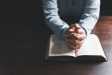 Kadın elleri İncil 'le Tanrı' ya dua ediyor. Kadınlar daha iyi bir hayat dilemek için Tanrı 'ya dua ederler. Af diliyor ve iyiliğe inanıyor. Kilisenin inanç kavramında kutsal İncil.