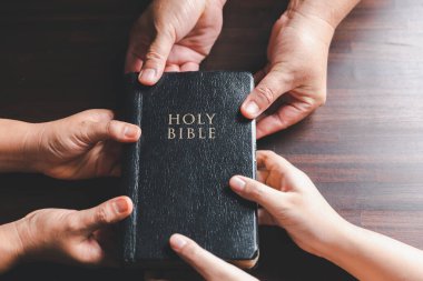 Hıristiyan küçük grup, ahşap bir masanın etrafında İncil sayfası ile birlikte dua ediyor. Hıristiyan grup dünya ve dünyanın dört bir yanındaki insanlar İncil 'le ahşap masada dua ediyor..