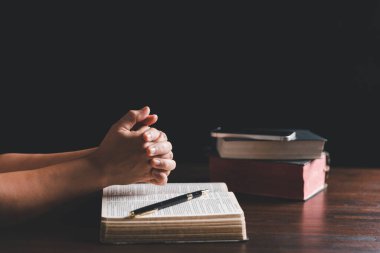 Christian online technology concept. Hands praying of christian with digital computer laptop, Online live church for sunday service. Asian catholic man are reading Holy bible book and online study.