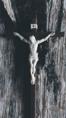 Ahşap Hıristiyan haçı, arka planda bir grunge tahtası. Ahşap Hıristiyan haçı gri masada bulanık ışıklara karşı, metin için boşluk.