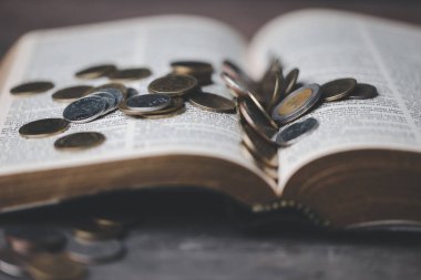 İncil 'in bize ilk meyvenin onda birini Tanrı' ya bağışlamayı öğrettiği onuncu ya da onuncu vergidir. Kutsal İncilli sikkeler. Din bağışı ve finansman. Para vermek, Hıristiyanlık bağışı sembolü.