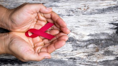 Güzel bir kırmızı kurdele, yardımın, desteğin ve kampanyanın sembolüdür. Bir el kırmızı bir kurdele tutuyor. Kurdelelerin mavi, beyaz, pembe, turuncu beyaz ve mor gibi pek çok farklı rengi vardır.