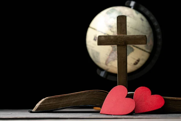 The red heart on holy bible book is the symbol of love from God. The God gives love to all people. We can see or find bible at the church. The bible is the in Christianity religion. Two heart on page.