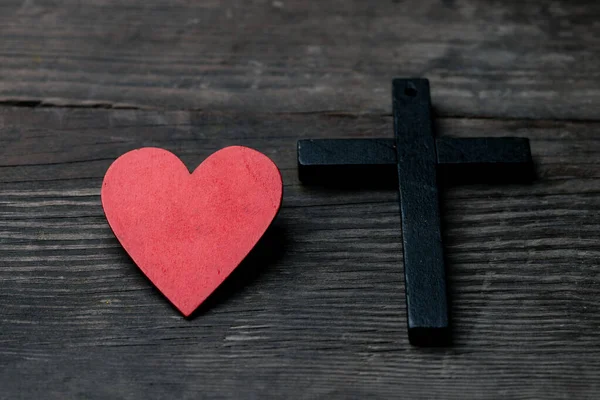 黑色背景上的红心 包括心脏旁边的交叉 十字架是基督教的象征 上帝爱每一个人 帮助每一个人 星期日去教堂祈祷和敬拜 — 图库照片