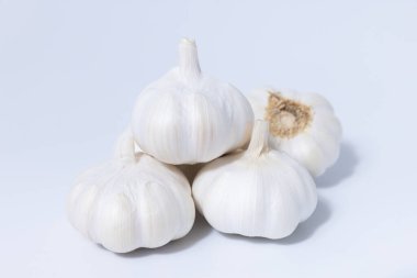 Beyaz arka planda taze sarımsaklı otlar. Bu mutfak malzemesi yemeklerinize doğal tat ve aroma katıyor. Gurme yemek ve yemek tasarımı için ideal. Her tarife lezzetli bir ilave..