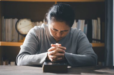 Hristiyan hayatı, Tanrı 'ya dua etmek. Daha iyi bir hayat dilemek için Tanrı 'ya dua et. Kadın elleri İncil 'le Tanrı' ya dua ediyor. Bağışlanmak için yalvarıyor ve iyiliğe inanıyordu..