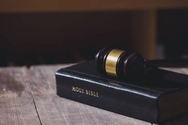 Kutsal İncil kitabı ve arka plandaki yargıç tokmağı. Yargı sistemi, anayasa, demokrasi, hukukun üstünlüğü. Fotoğrafta hiç insan yok. Eklemek için boş alan var.