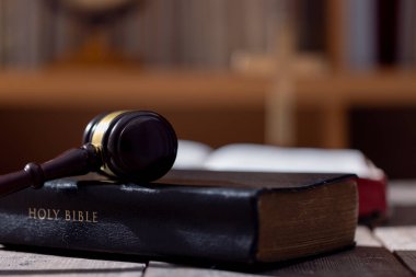 Kutsal İncil kitabı ve arka plandaki yargıç tokmağı. Yargı sistemi, anayasa, demokrasi, hukukun üstünlüğü. Fotoğrafta hiç insan yok. Eklemek için boş alan var.
