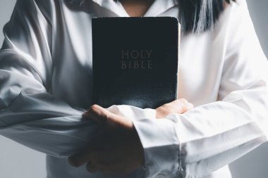 İncil konsepti olan Hristiyanlara tapmak. Evde ders çalışarak İncil 'i tutan genç bir kadın. Kilisede yetişkin bir Hıristiyan kadın kitap okuyor. Din maneviyatını öğrenen ve Tanrı 'ya dua eden bir kız..