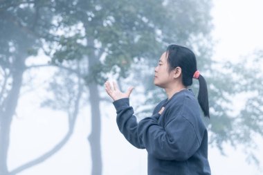 Hristiyan kadınlar sisli bir sabahta Tanrı 'ya ibadet ederler. İnsanların elleri inanç ve umutla dua ediyor. İnanç, maneviyat, din kavramı.